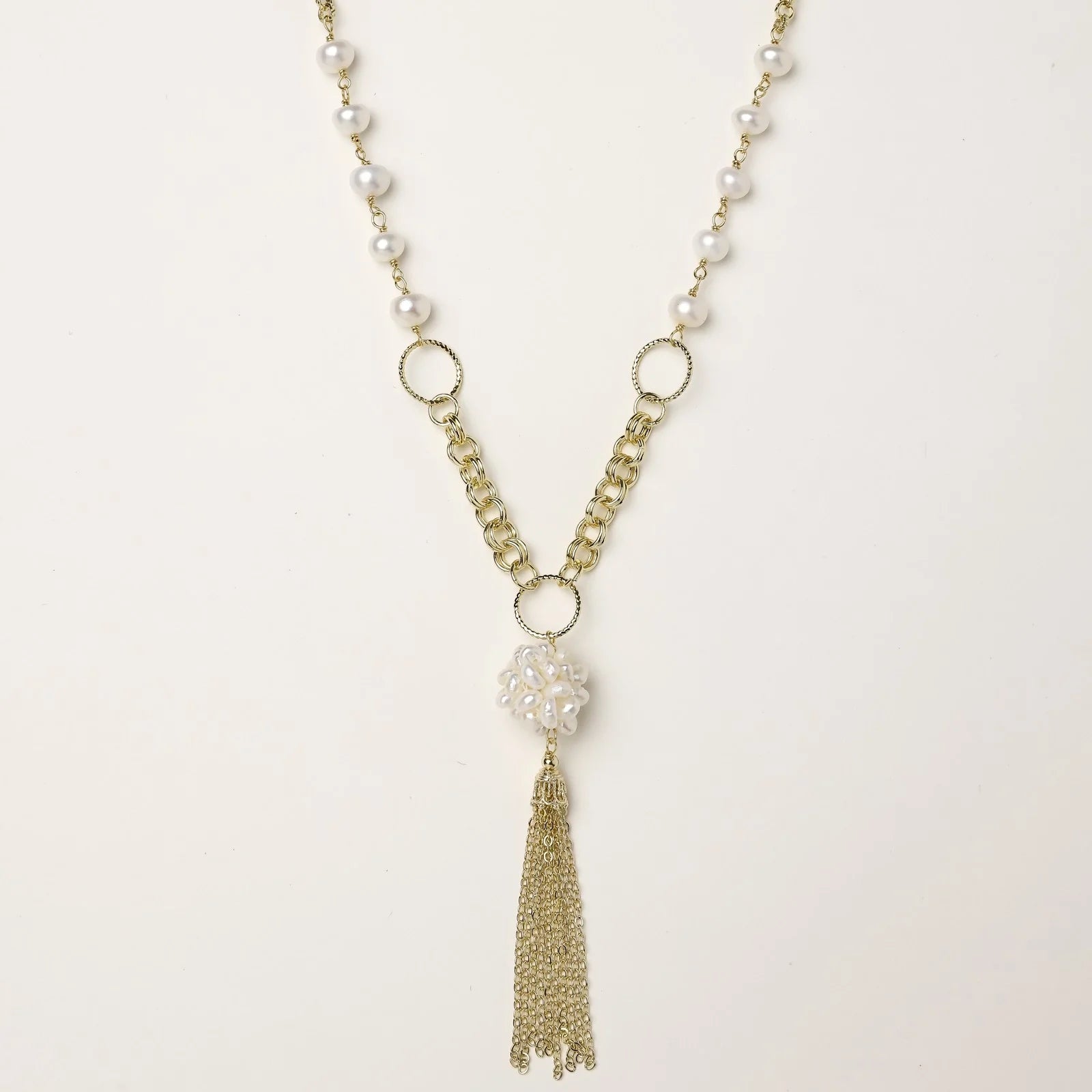 Long gold-plated necklace with freshwater pearls, chunky chain links, and flowing tassel pendant